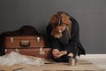 Poor homeless woman with suitcase counting coins