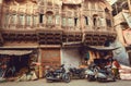 Poor houses with ancient carvings and people buying something in local indian stores