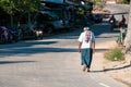 Poor humpback old man walking in exotic asian street.