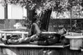 Poor hungry and tired homeless veteran man ex military soldier sleep in the shade on the bench in urban city street social documen Royalty Free Stock Photo