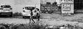 Poor kids walking by themselves on a mud road in Recife, Brazil, grayscale shot