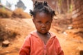 Poor little girl wearing dirty clothes in an African village, poverty and crisis concept Royalty Free Stock Photo