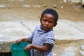 Poor malagasy boy carrying plastic water bucket Royalty Free Stock Photo