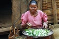 Poor Malagasy woman preparing food in front of cabin Royalty Free Stock Photo