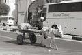 Poor man caring merchandise in buggy pull by a donkey