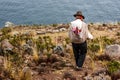 Poor man walking down a cliff, Taquile Island, Titicaca lake, Peru