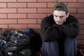 Poor man sitting hunched on the ground Royalty Free Stock Photo