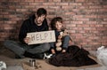 Poor man with his son asking for help