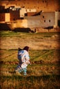 Poor muslin old lady and child walk in old traditional Morocco Arab Medina and village. Royalty Free Stock Photo