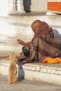 Poor old Indian man giving food to a pup Royalty Free Stock Photo