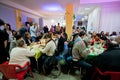 Poor people sit around tables with food at the Christmas charity dinner for the homeless