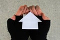 Poor person holding a house made out from Origami art of paper folding Royalty Free Stock Photo