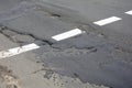 Poor quality of road repair work. Damaged asphalt road, bad road. Royalty Free Stock Photo