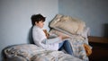 Poor sad small girl on bed indoors at home, poverty concept. Royalty Free Stock Photo