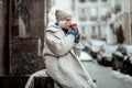 Poor senior woman drinking tea on the street