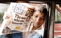 Poor street boy in India selling newspapers