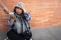 Poor tired stressed depressed elderly Asian woman homeless sitting on the street in the shadow of the building and begging for Royalty Free Stock Photo
