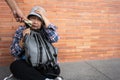 Poor tired stressed depressed elderly Asian woman homeless sitting on the street in the shadow of the building and begging for