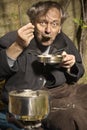 Poor unemployed man on backstreet yard place eating lentil soup Royalty Free Stock Photo