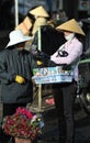 A poor woman in busy market in Vietnam