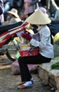 A poor woman in busy market in Vietnam