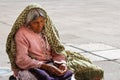 Poor woman sitting near church