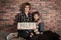 Poor woman with her son asking for help