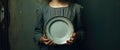 a poor young girl holding a empty plate. poverty and hunger concept. beggar, begging.