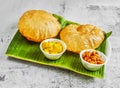 poori set or puri with chnnay and veg curry with chutney, raita and sauce served in dish isolated on banana leaf top view of Royalty Free Stock Photo