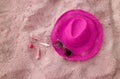 Pop art shocking pink straw hat with sunglasses and little seashells on pastel pink sandy beach Royalty Free Stock Photo