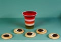 Pop art still life. Plastic glass striped jelly and biscuits