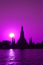 Purple Colored Wat Arun or The Temple of Dawn with Bright Sun on Chao Phraya Riverbank, Bangkok, Thailand Royalty Free Stock Photo