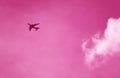 Surreal image of jet plane flying on pink sky Royalty Free Stock Photo