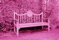 Surreal style empty wooden bench with hedging shrub in orchid pink Royalty Free Stock Photo