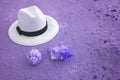 Pop art surreal white straw hat on the sand beach with seashells in purple color