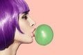 Pop art woman blowing bubble gum. Side view on pink background. Royalty Free Stock Photo