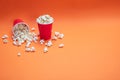 Pop corn scattered on orange color background, top view