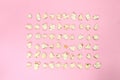 Pop corn seeds symmetric on pink paper