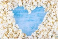 Pop corn in the shape of heart on blue background