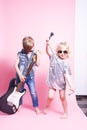 Pop Culture: Children a boy with a guitar and a girl with a microphone pretend to be popular musicians and perform a home concert