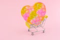 Pop it in the shape of a heart on a shopping trolley. Children`s modern toy pop it fidget in female hands