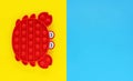 Pop it toy in shape of Red crab popular antistress sensory game. Holidays summer yellow and blue background with place for text.