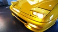 Pop-up headlights of a yellow 1999 Ferrari F355 F1 Spider