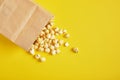 Popcorm paper bag on a yellow background Royalty Free Stock Photo