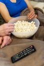 Popcorn bowl detail. Unrecognizable man and woman.