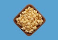 Popcorn in a bowl isolated on blue background. Top view Royalty Free Stock Photo