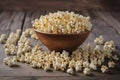 Popcorn into a bowl over a wooden table Royalty Free Stock Photo