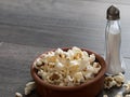Popcorn in a bowl with salt on a wooden background Royalty Free Stock Photo