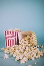 Popcorn bucket against a blue background Vintage Retro Filter. Royalty Free Stock Photo