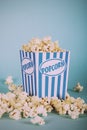 Popcorn bucket against a blue background Vintage Retro Filter. Royalty Free Stock Photo